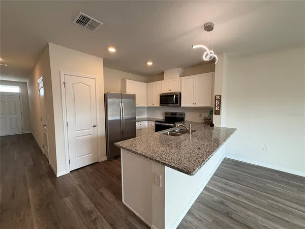 a kitchen with stainless steel appliances granite countertop a refrigerator and a sink