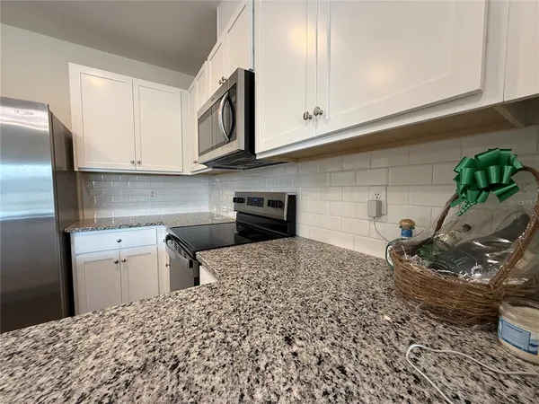 a kitchen with a stove and white cabinets