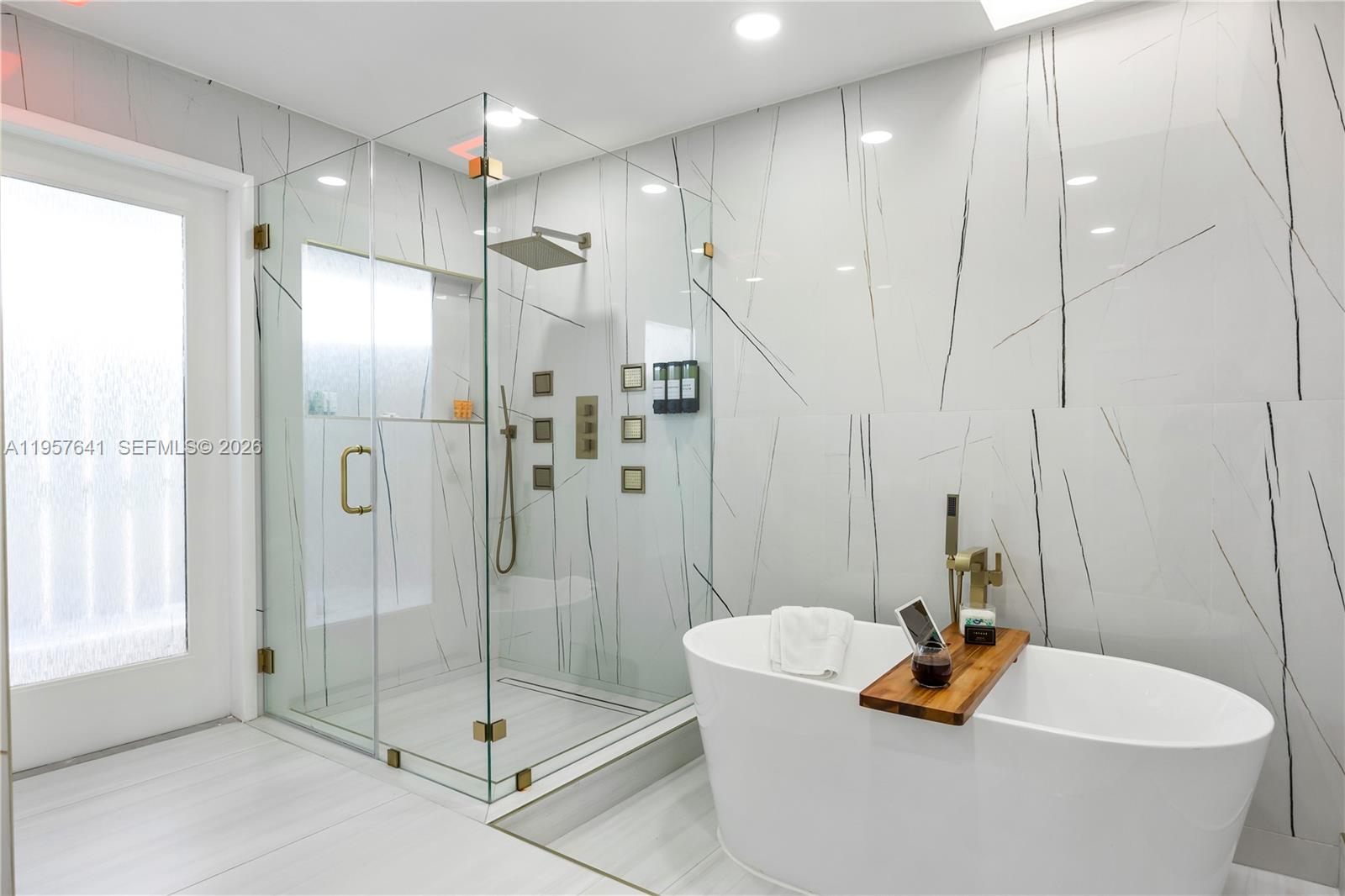 2532 Southeast 13th Street Pompano Beach, FL 33062 - Photo 11 of 69 a bathroom with a tub a window and a glass door shower