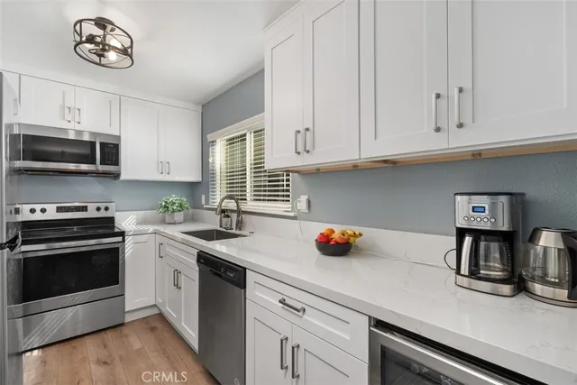 a kitchen with stainless steel appliances white cabinets and a sink