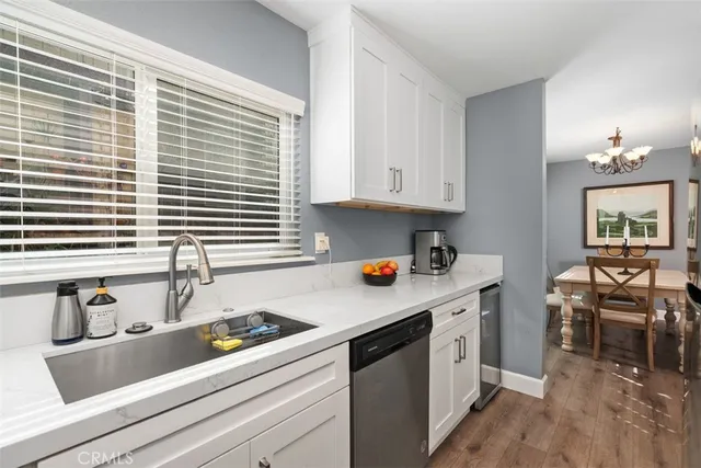 a kitchen with stainless steel appliances granite countertop a sink and a white wooden cabinets