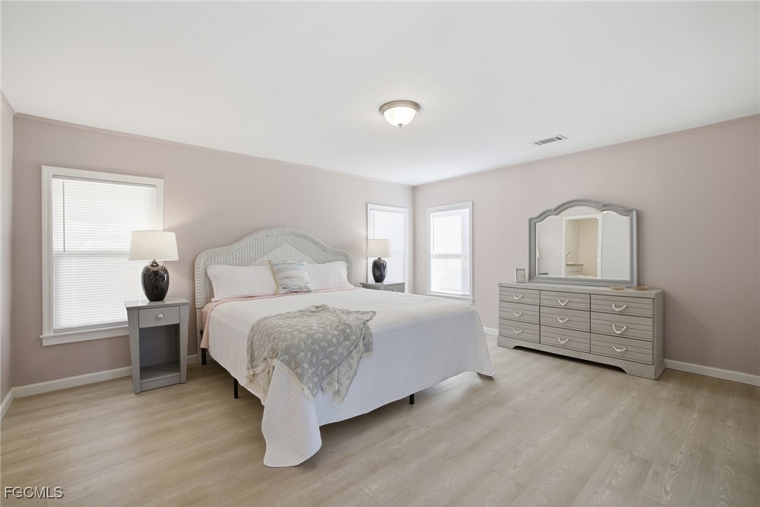 14736 Patrick Henry Road North Fort Myers, FL 33917 - Photo 13 of 47 a bedroom with a bed and wooden floor