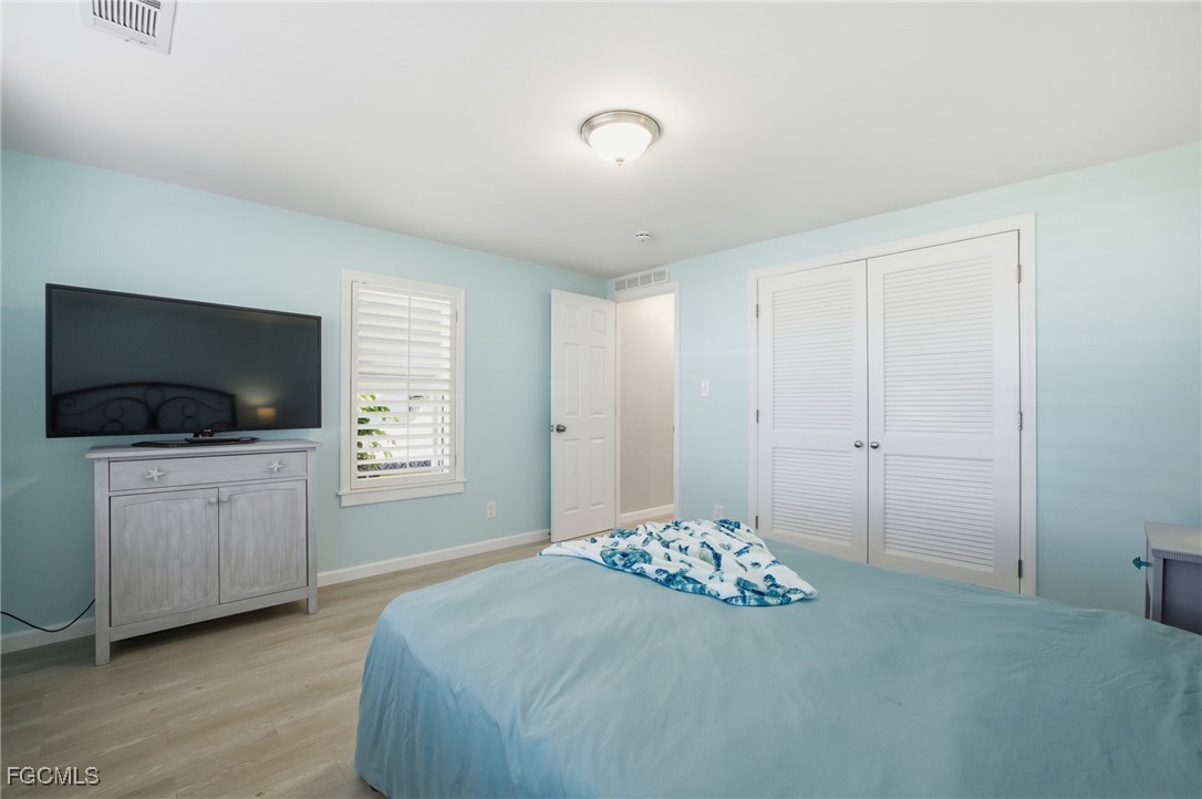 14736 Patrick Henry Road North Fort Myers, FL 33917 - Photo 24 of 47 a bedroom with a bed and a flat screen tv