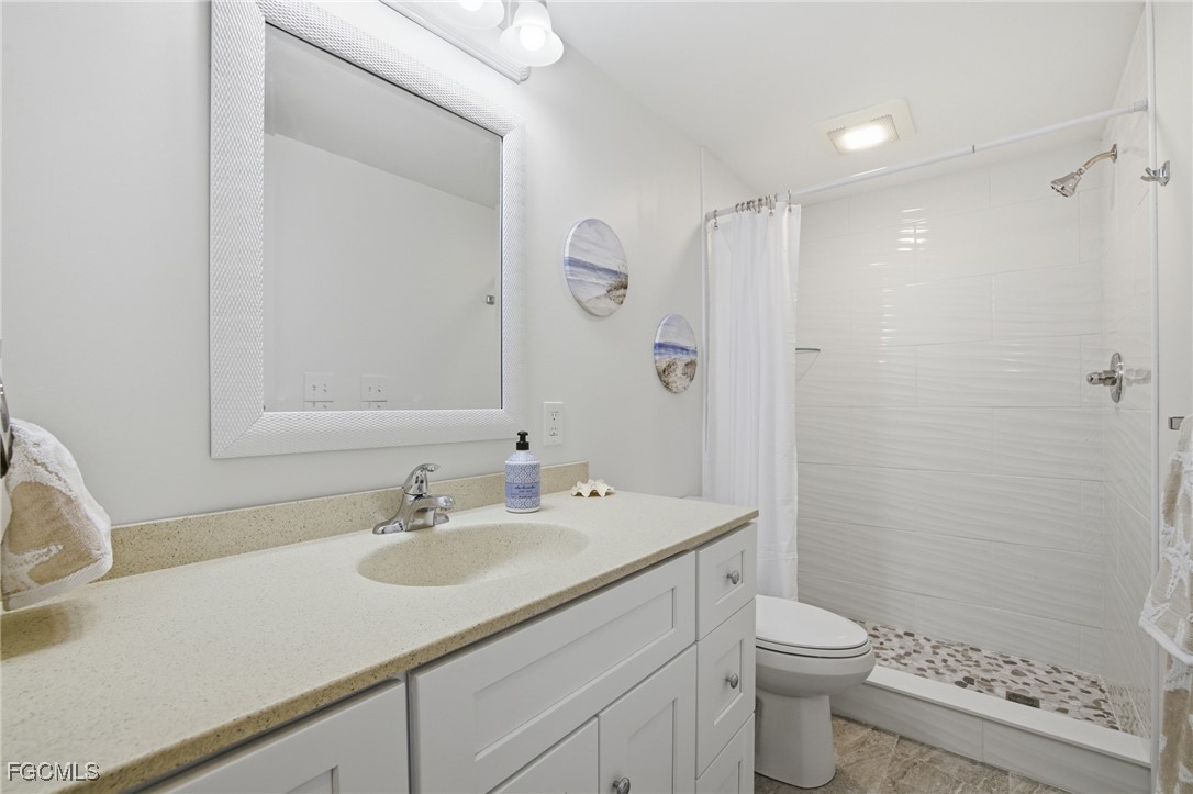 14736 Patrick Henry Road North Fort Myers, FL 33917 - Photo 26 of 47 a bathroom with a sink a toilet a shower and a mirror