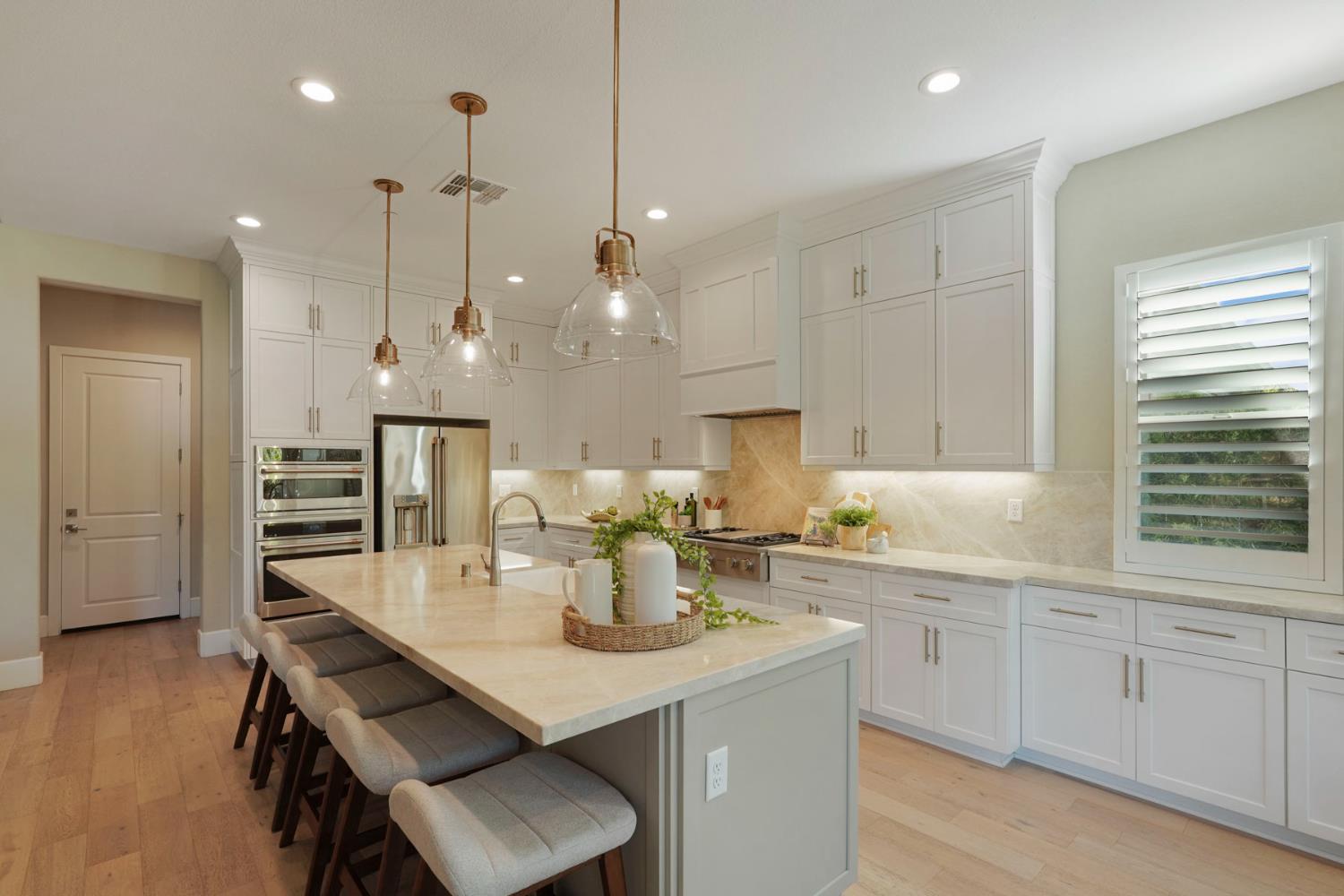 2931 Concerto Court Lodi, CA 95242 - Photo 16 of 54 a kitchen with kitchen island a dining table chairs cabinets and wooden floor