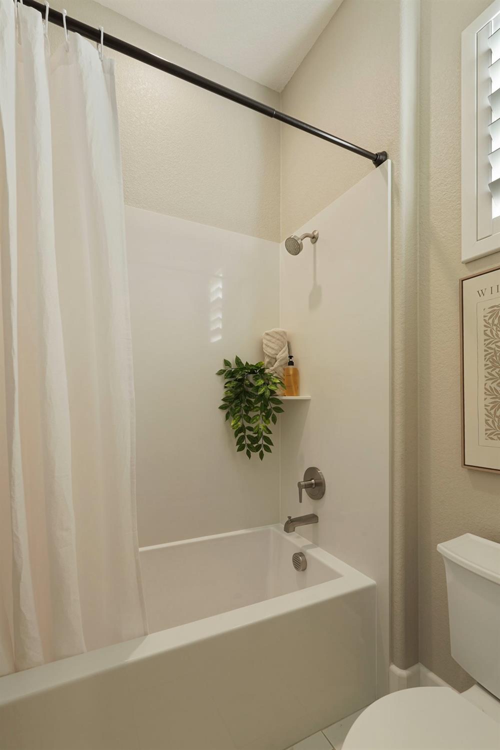 2931 Concerto Court Lodi, CA 95242 - Photo 29 of 54 a white bath tub with a shower curtain
