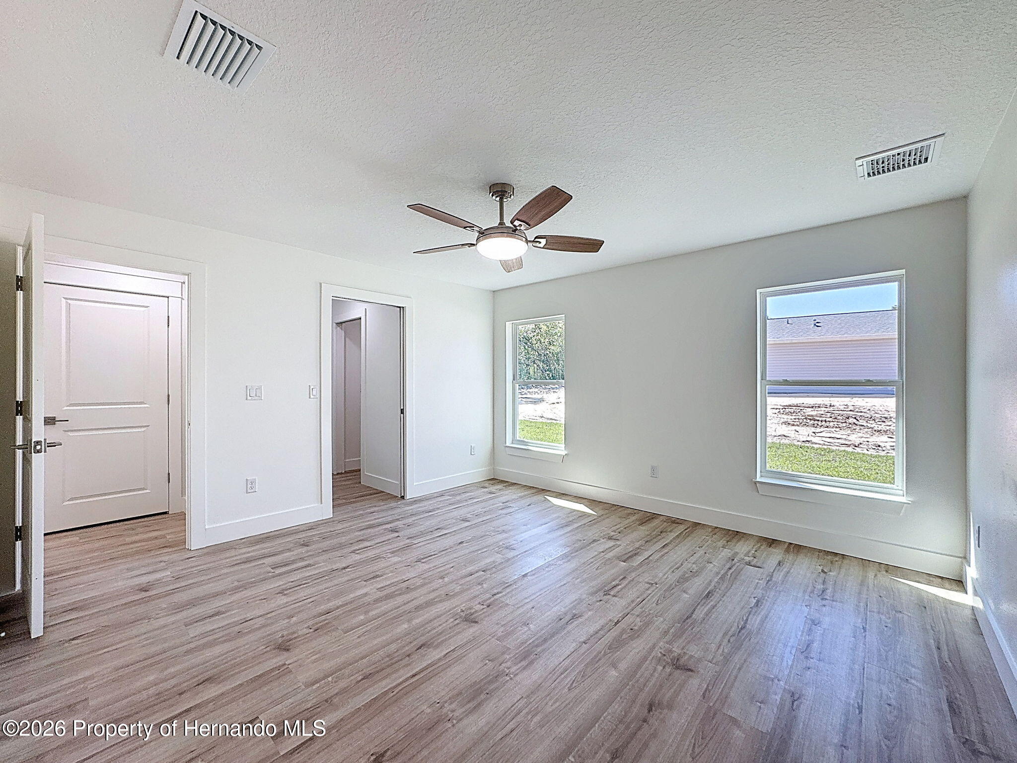 8988 Waterbird Way Weeki Wachee, FL 34613 - Photo 23 of 42 an empty room with wooden floor and windows