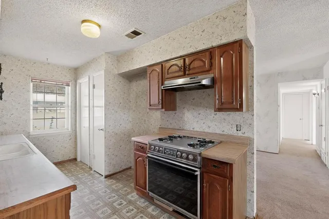 a kitchen with stainless steel appliances granite countertop a stove and a sink