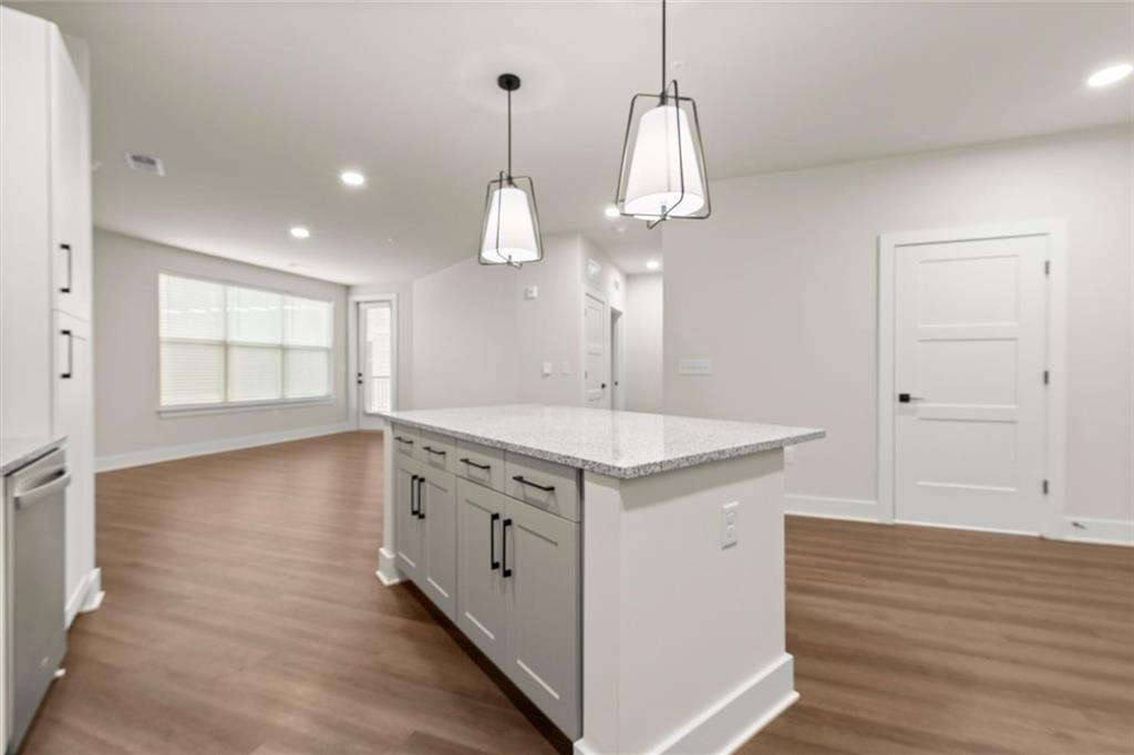 2648 Sandy Plains Road, Unit 422 Marietta, GA 30066 - Photo 7 of 37 a kitchen with granite countertop white cabinets and a wooden floor