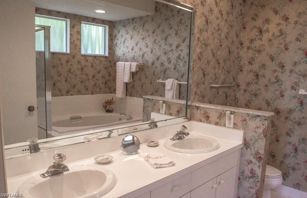 5817 Glencove Drive, Unit 404 Naples, FL 34108 - Photo 13 of 21 a bathroom with a sink and a mirror