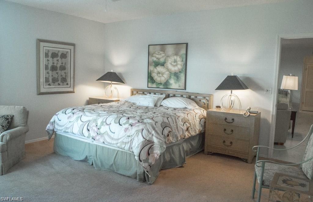 5817 Glencove Drive, Unit 404 Naples, FL 34108 - Photo 14 of 21 a bedroom with a bed and a lamp on dresser