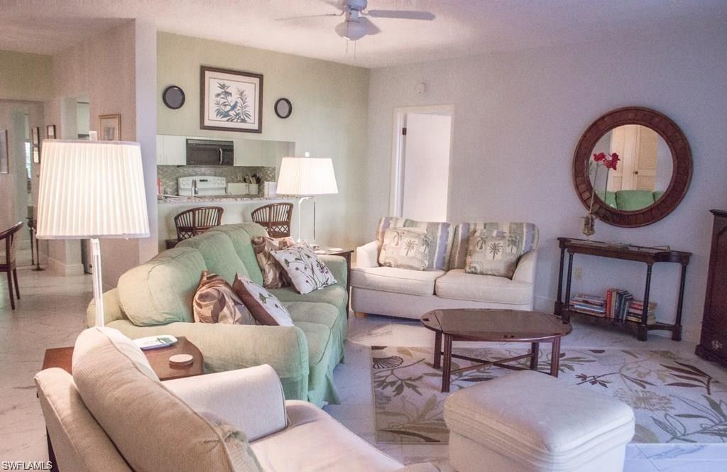 5817 Glencove Drive, Unit 404 Naples, FL 34108 - Photo 2 of 21 a living room with furniture a rug and a window