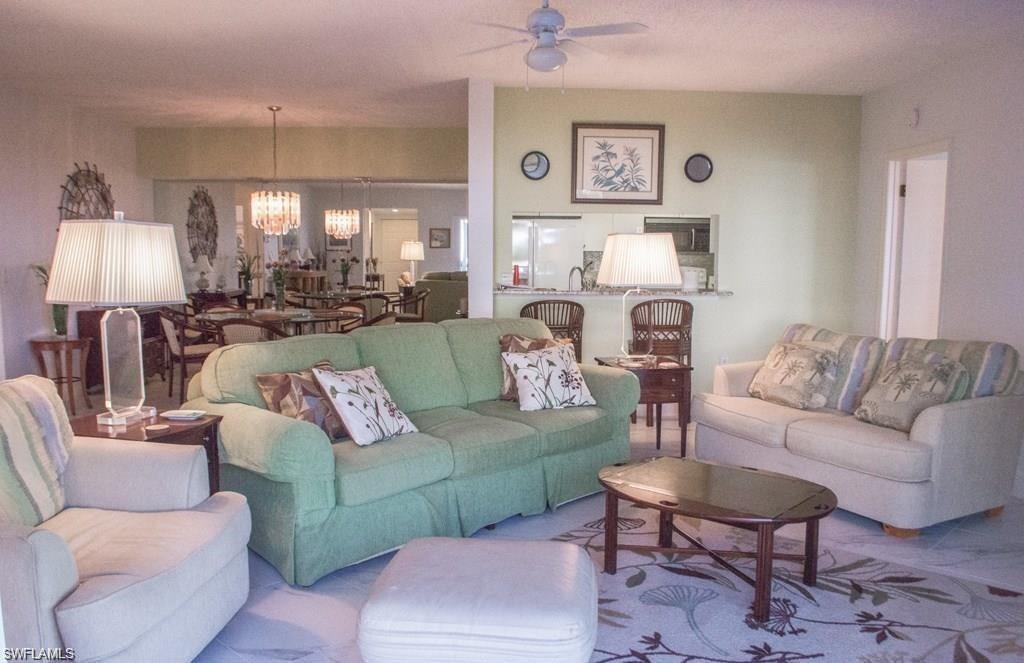 5817 Glencove Drive, Unit 404 Naples, FL 34108 - Photo 3 of 21 a living room with furniture and a lamp