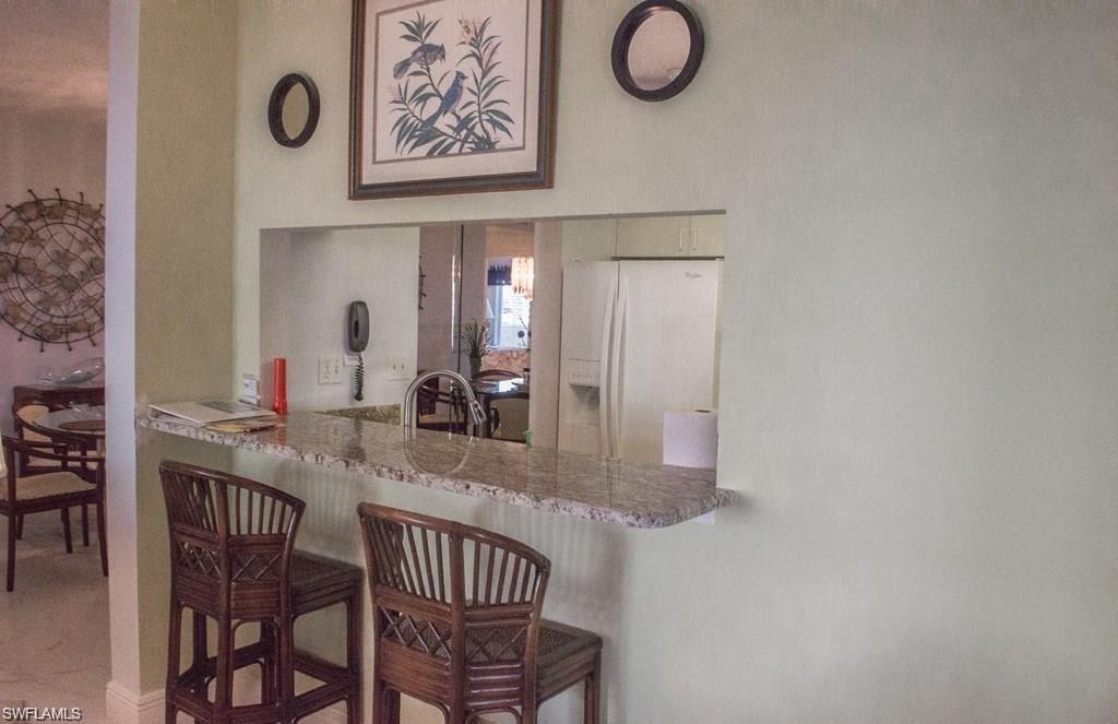 5817 Glencove Drive, Unit 404 Naples, FL 34108 - Photo 7 of 21 a kitchen with stainless steel appliances granite countertop a sink and cabinets