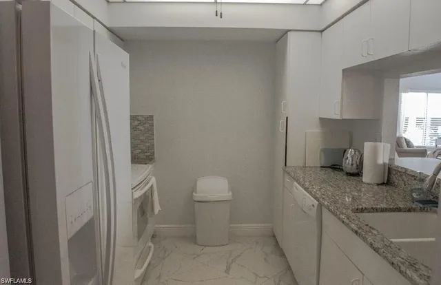 a bathroom with a granite countertop toilet and a sink