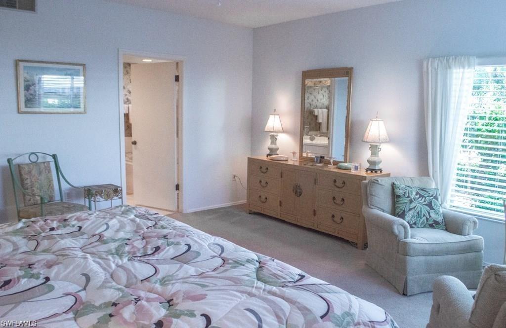 5817 Glencove Drive, Unit 404 Naples, FL 34108 - Photo 9 of 21 a bedroom with a bed and a couch