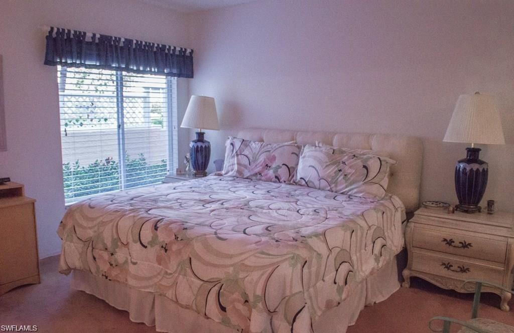 5817 Glencove Drive, Unit 404 Naples, FL 34108 - Photo 10 of 21 a bedroom with a bed and a window