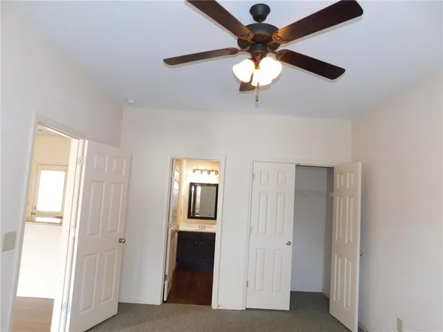 a view of a hallway with a chandelier fan and windows