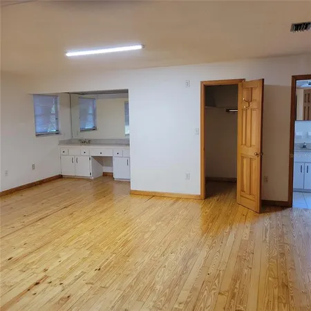 an empty room with a window and a fan