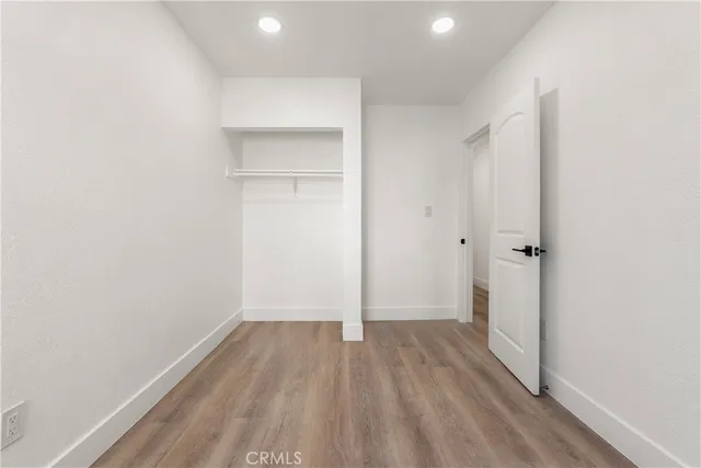 a view of a room with wooden floor and a ceiling fan