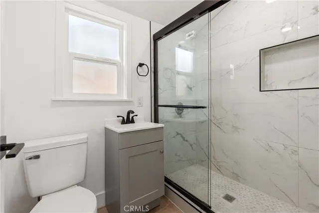 a bathroom with a toilet sink vanity and tub
