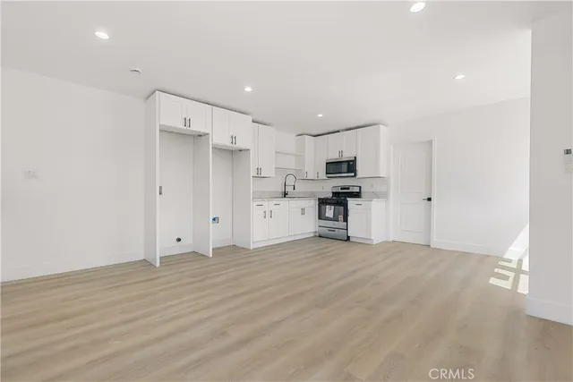 a view of kitchen with refrigerator stove microwave and cabinets