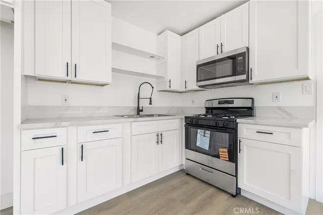 a kitchen with white cabinets and white appliances