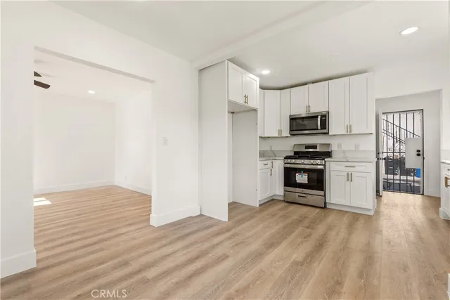 a kitchen with stainless steel appliances a refrigerator and a stove top oven
