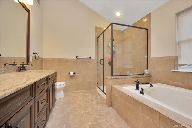 a bathroom with a granite countertop sink a mirror and a bathtub
