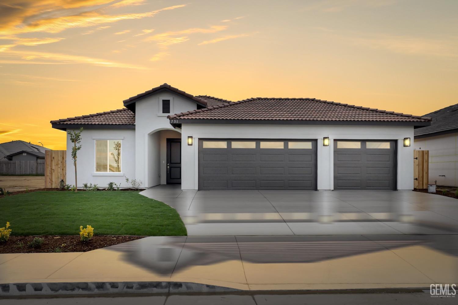 a front view of a house with a garden and yard