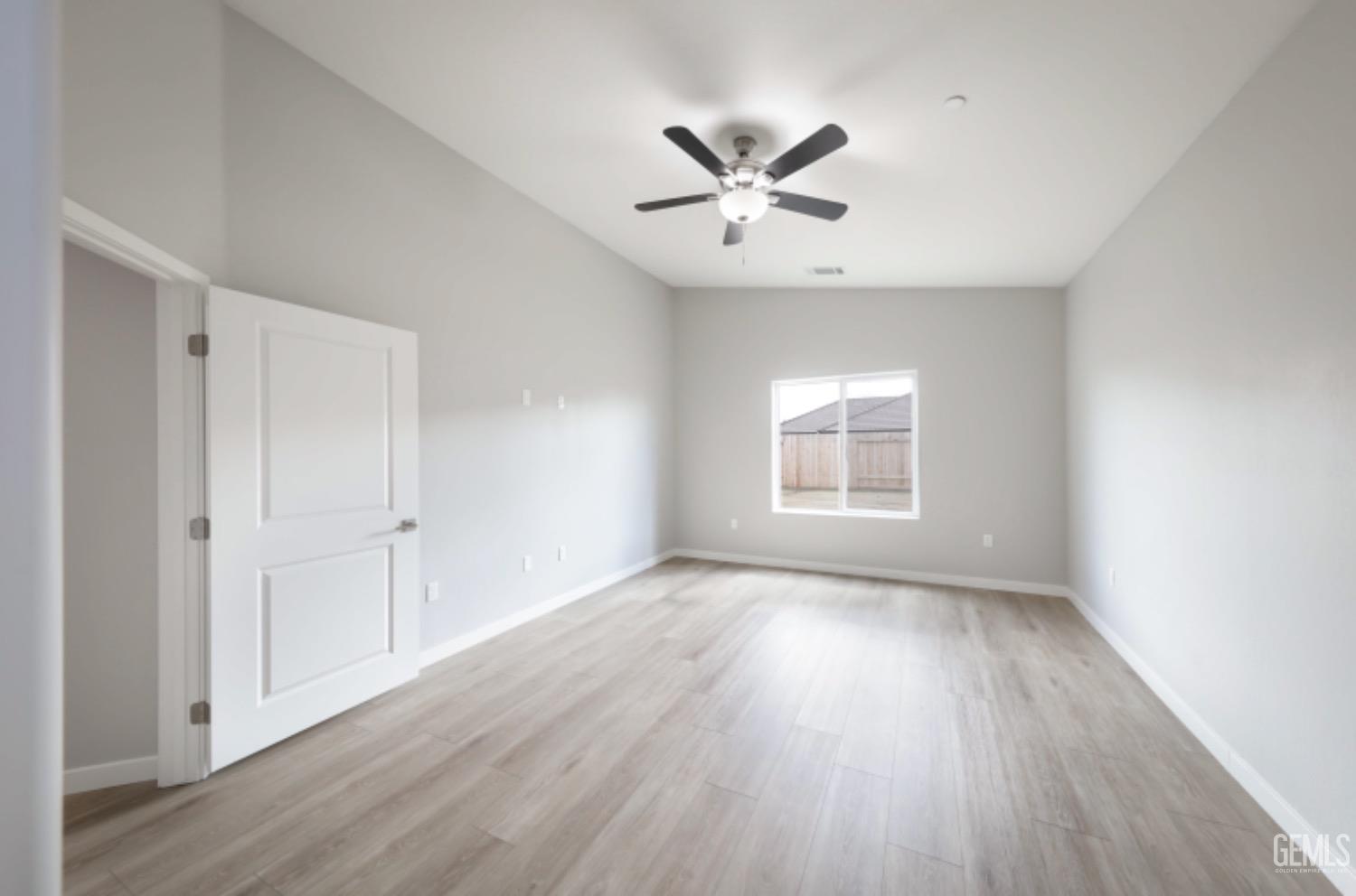 Undisclosed Address Shafter, CA 93263 - Photo 20 of 33 a view of an empty room with wooden floor and a window