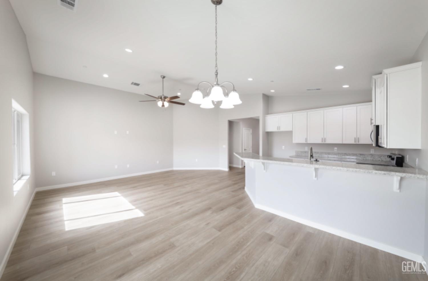 Undisclosed Address Shafter, CA 93263 - Photo 25 of 33 a view of a kitchen with kitchen island a sink dishwasher and a fireplace with wooden floor