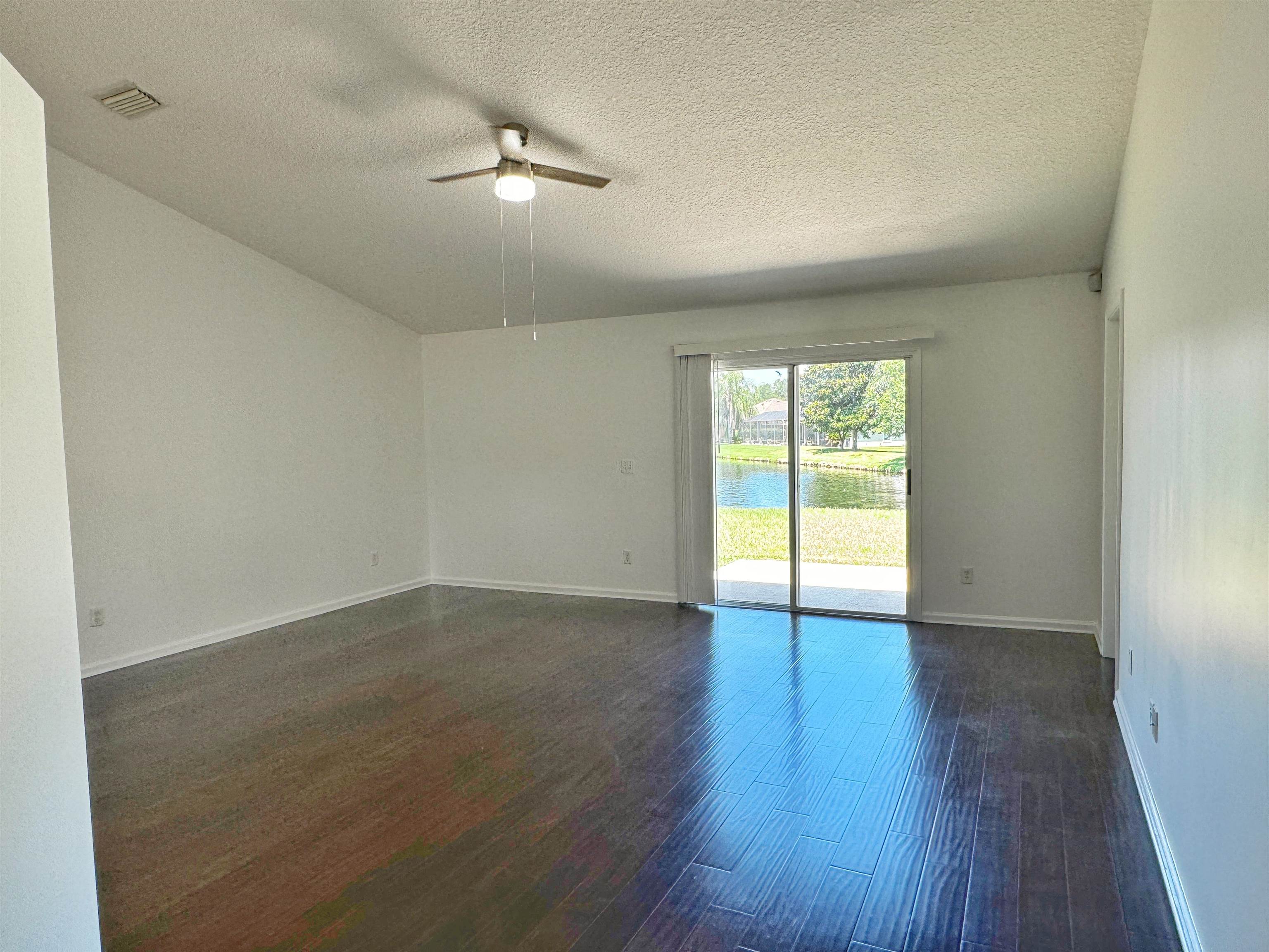 1709 South Summer Ridge Court St. Augustine, FL 32092 - Photo 13 of 27 an empty room with wooden floor and windows