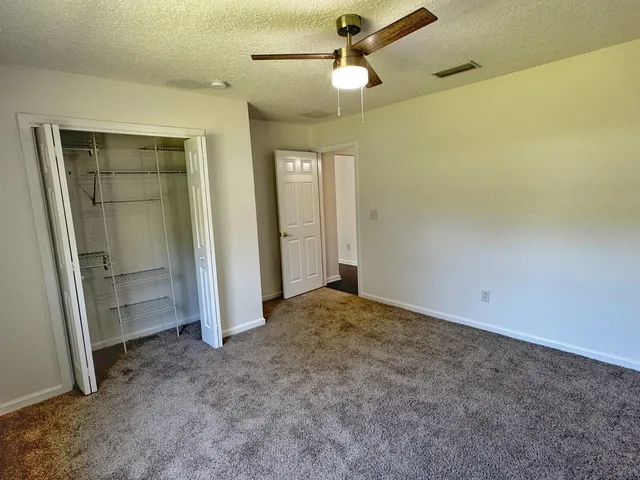 an empty room with closet and windows