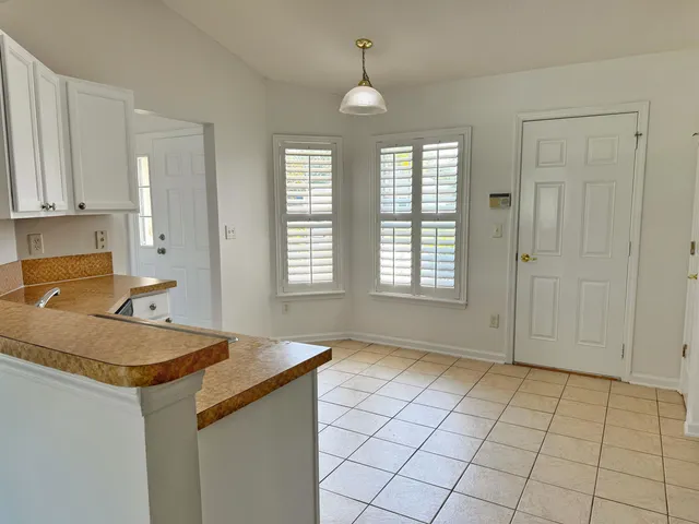 a view of a kitchen that shows a sink dishwasher and wooden floor