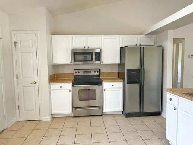 a kitchen with a refrigerator and a stove top oven