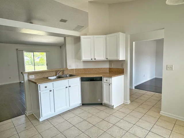 a kitchen with granite countertop white cabinets and white appliances