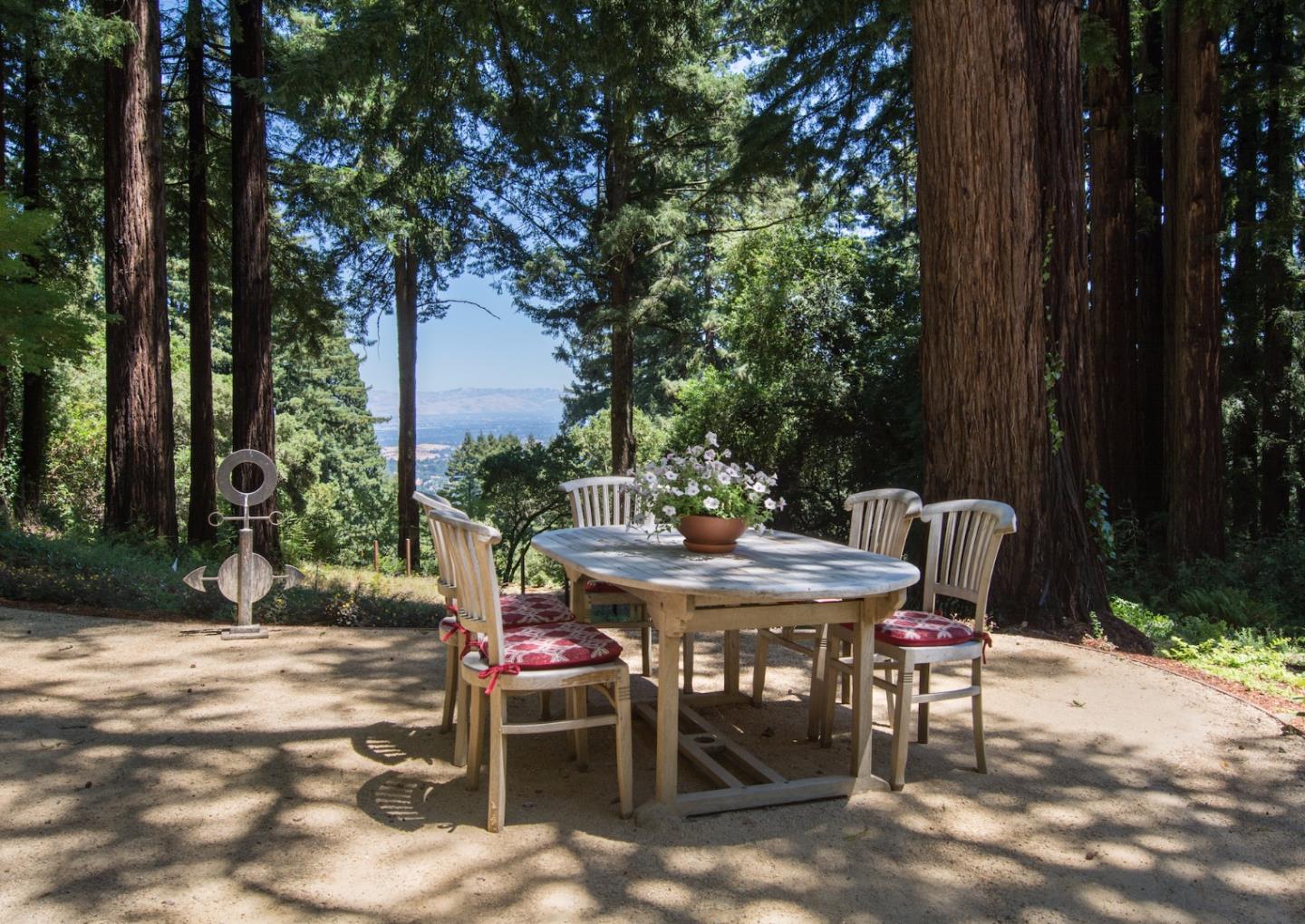 135 Summit Road Woodside, CA 94062 - Photo 18 of 27 a view of a backyard with table and chairs with a fire pit and a large tree