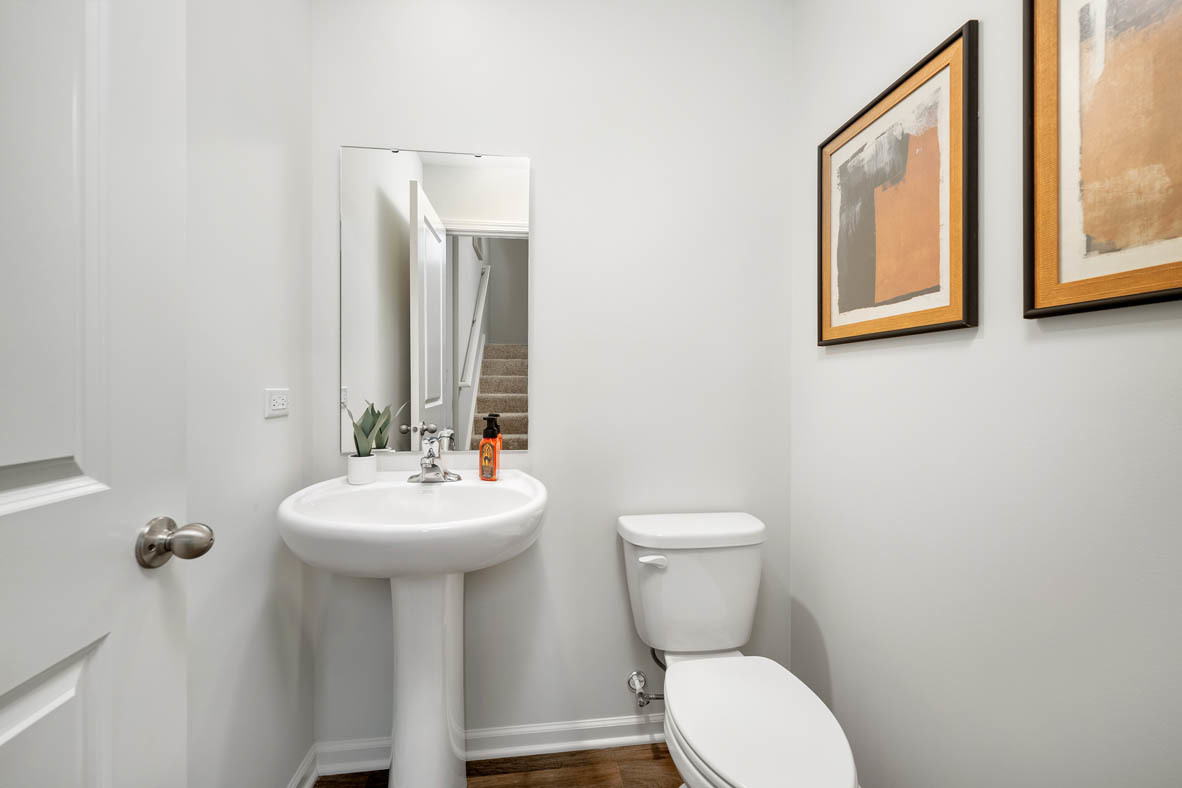 6388 Roscommon Road Tinley Park, IL 60477 - Photo 3 of 21 a bathroom with a toilet sink and mirror