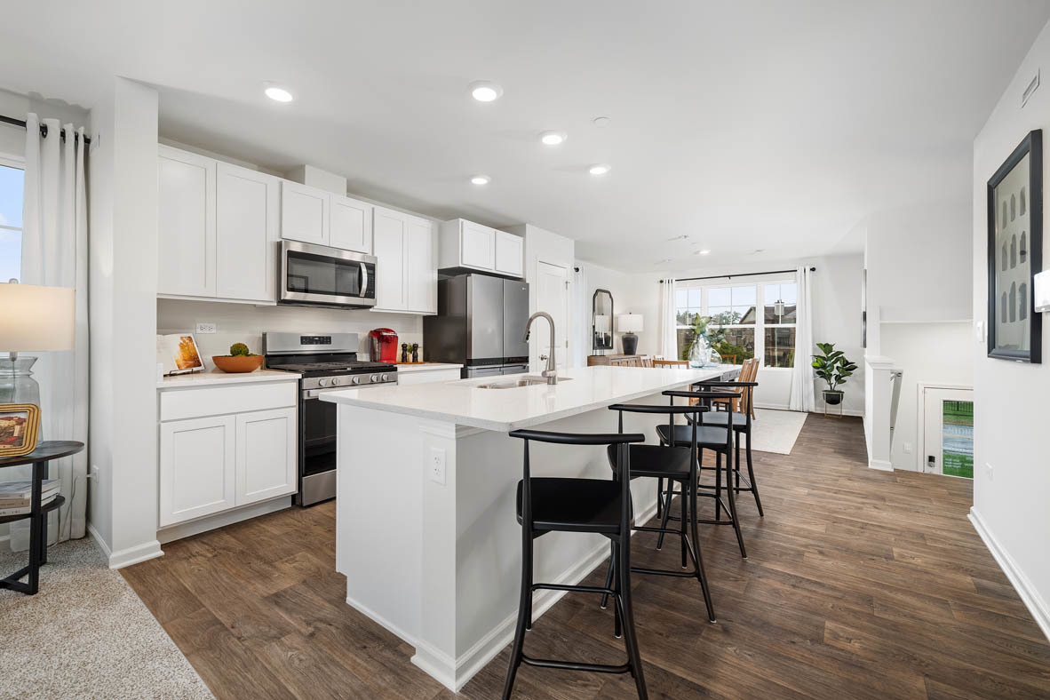 6388 Roscommon Road Tinley Park, IL 60477 - Photo 6 of 21 a kitchen with kitchen island granite countertop wooden floors a white center island and appliances