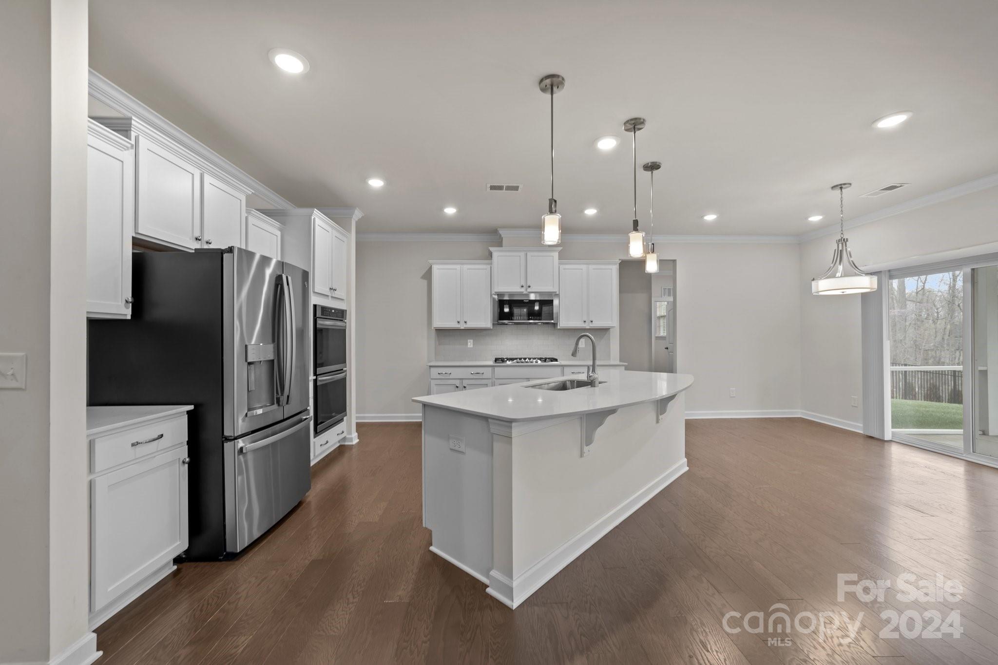 15741 Queens Trail Drive Davidson, NC 28036 - Photo 13 of 48 a kitchen with kitchen island a sink stainless steel appliances and cabinets