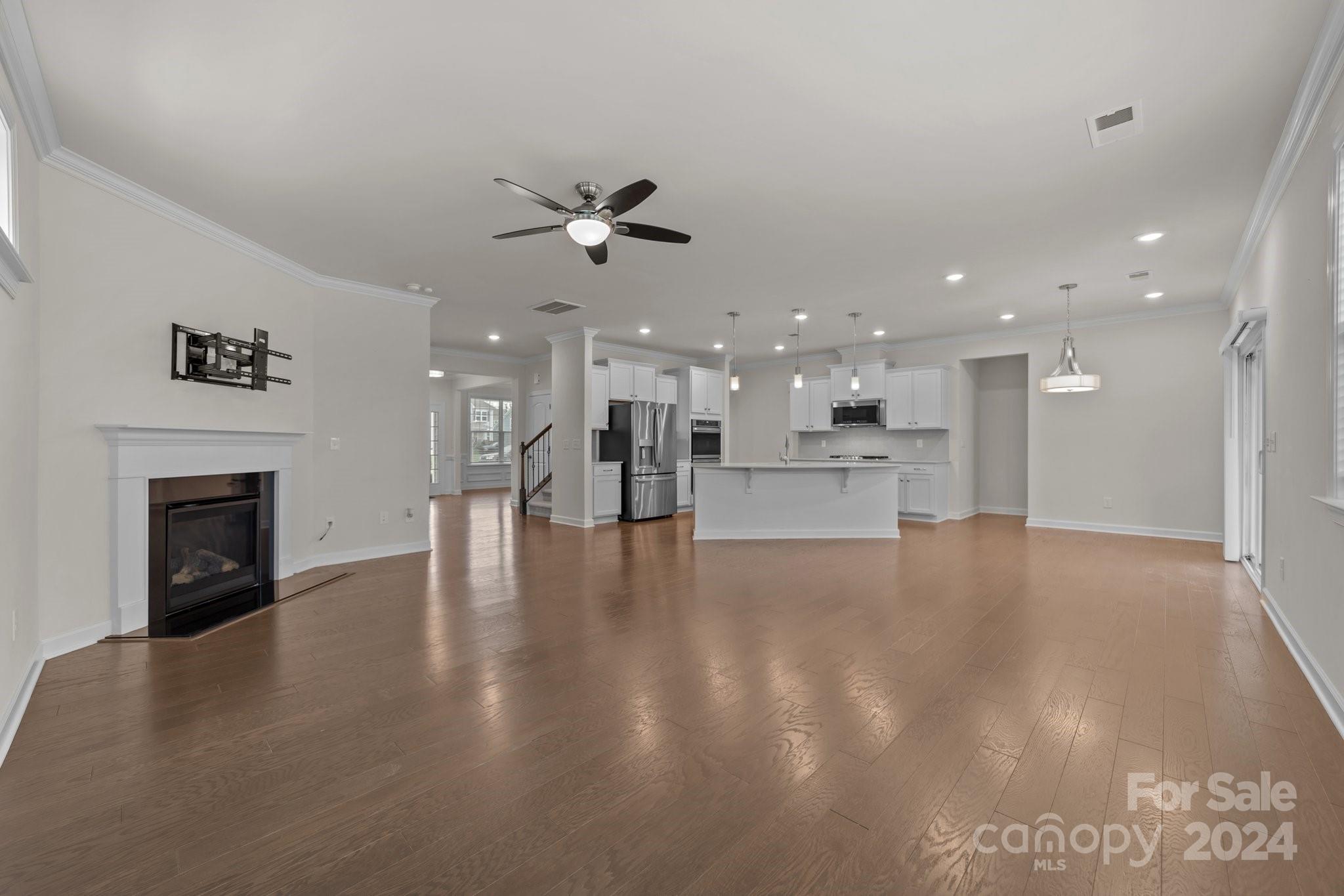 15741 Queens Trail Drive Davidson, NC 28036 - Photo 24 of 48 a view of an empty room and kitchen with fireplace wooden floor