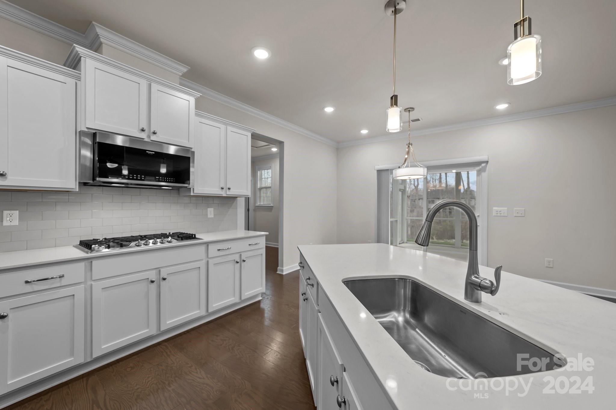 15741 Queens Trail Drive Davidson, NC 28036 - Photo 27 of 48 a kitchen with kitchen island a sink stainless steel appliances and cabinets
