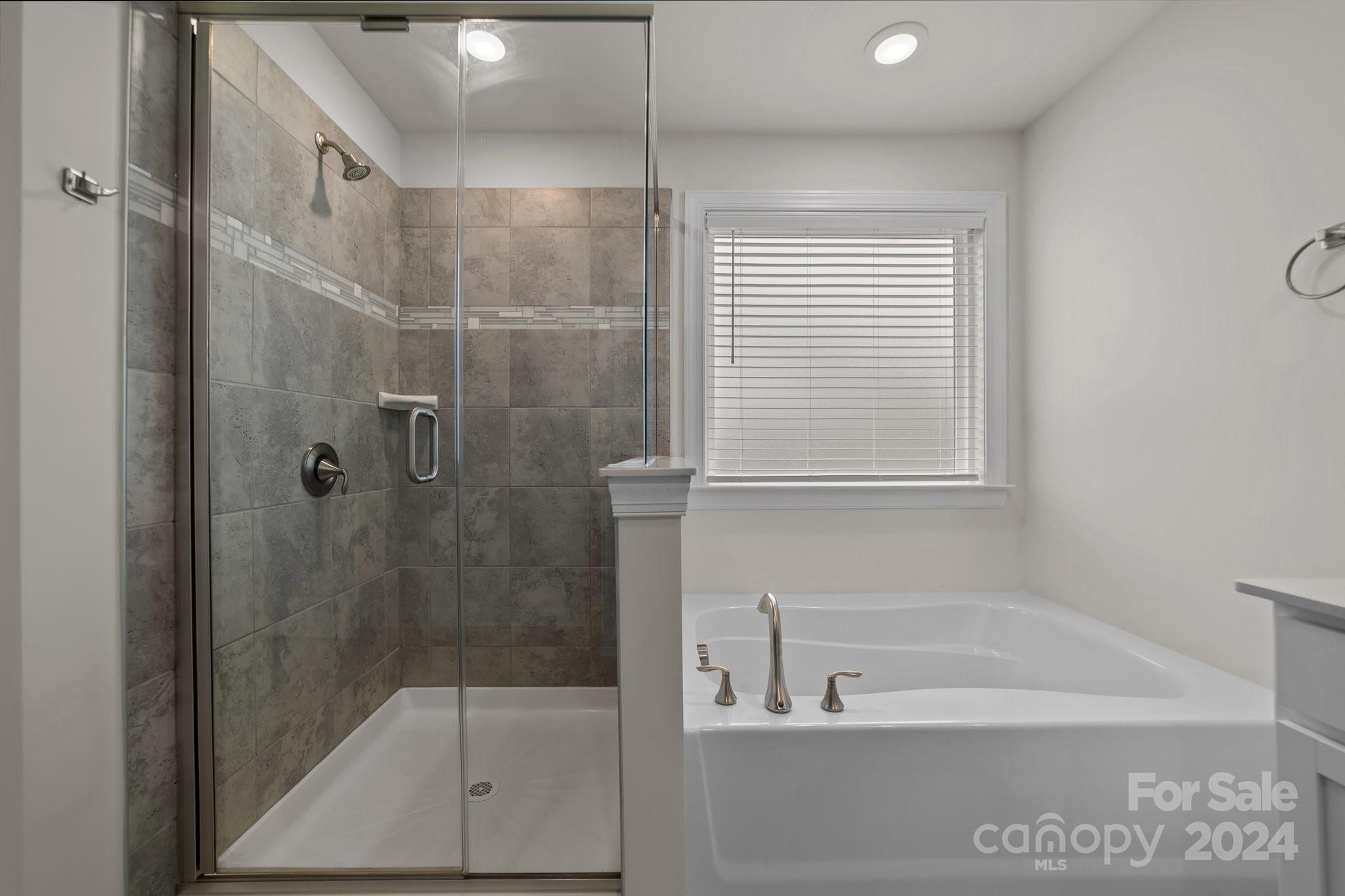 15741 Queens Trail Drive Davidson, NC 28036 - Photo 38 of 48 a bathroom with a bathtub and a shower