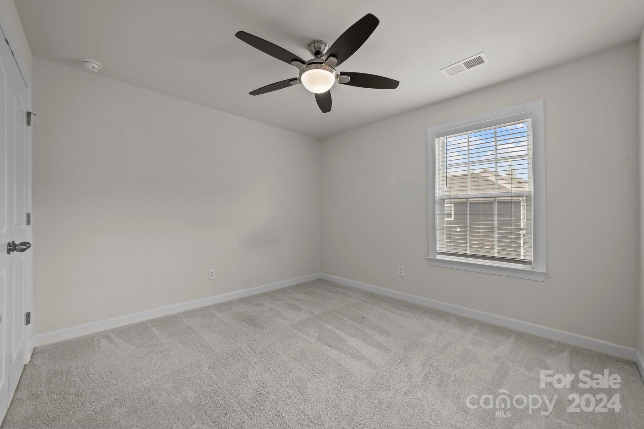 15741 Queens Trail Drive Davidson, NC 28036 - Photo 39 of 48 an empty room with ceiling fan and window