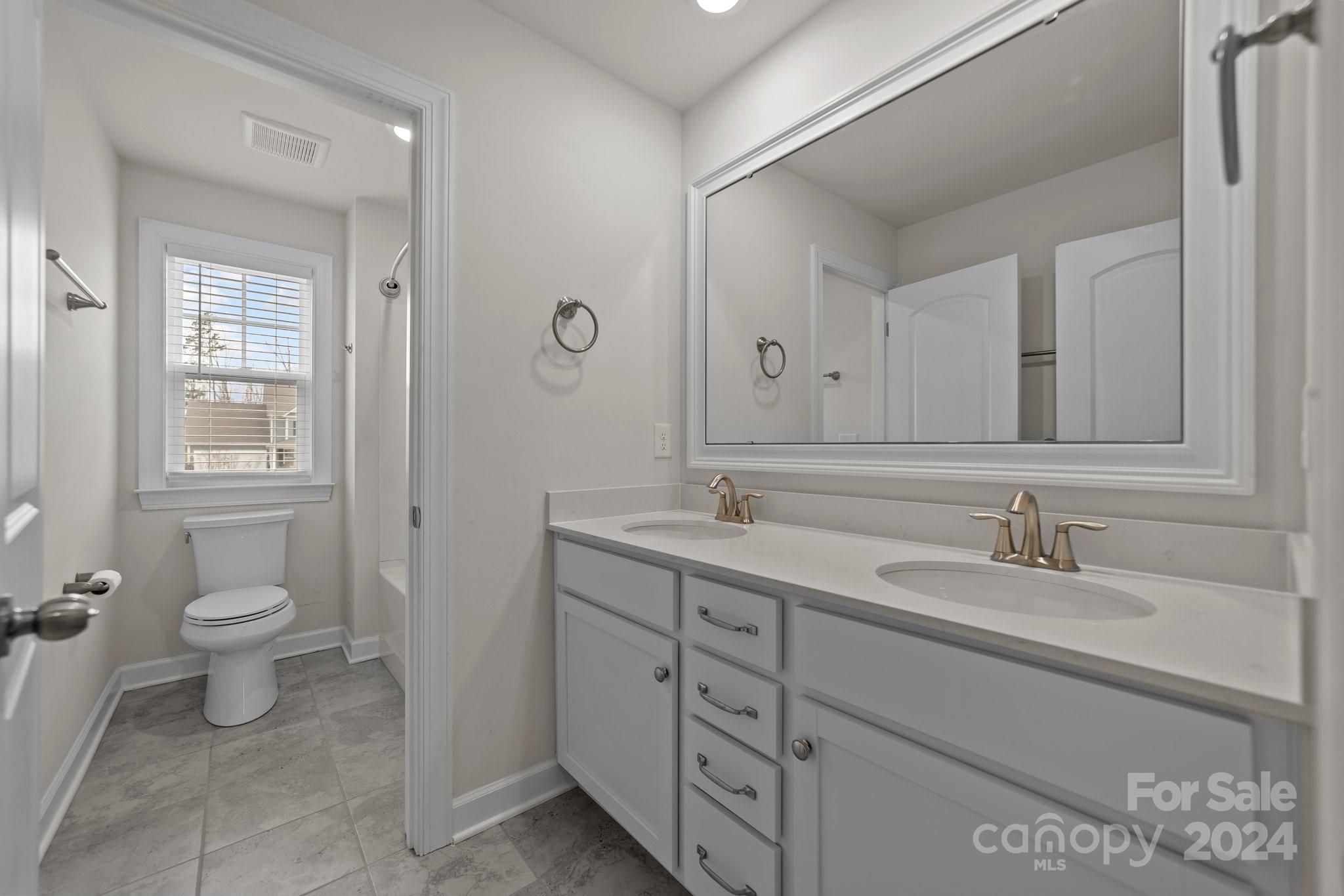 15741 Queens Trail Drive Davidson, NC 28036 - Photo 41 of 48 a bathroom with a toilet sink and mirror