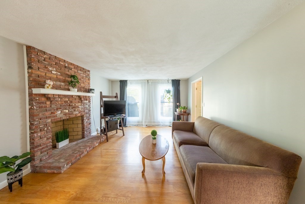 6 King Street Arlington, MA 02474 - Photo 11 of 37 a living room with furniture flat screen tv and a fireplace