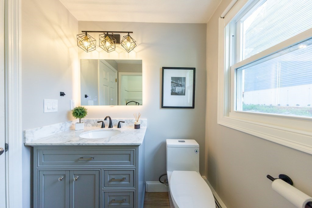 6 King Street Arlington, MA 02474 - Photo 14 of 37 a bathroom with a granite countertop toilet sink and mirror