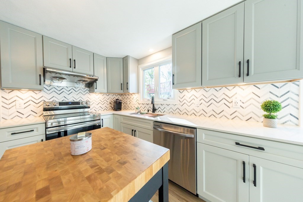 6 King Street Arlington, MA 02474 - Photo 2 of 37 a kitchen with kitchen island granite countertop a sink and white cabinets