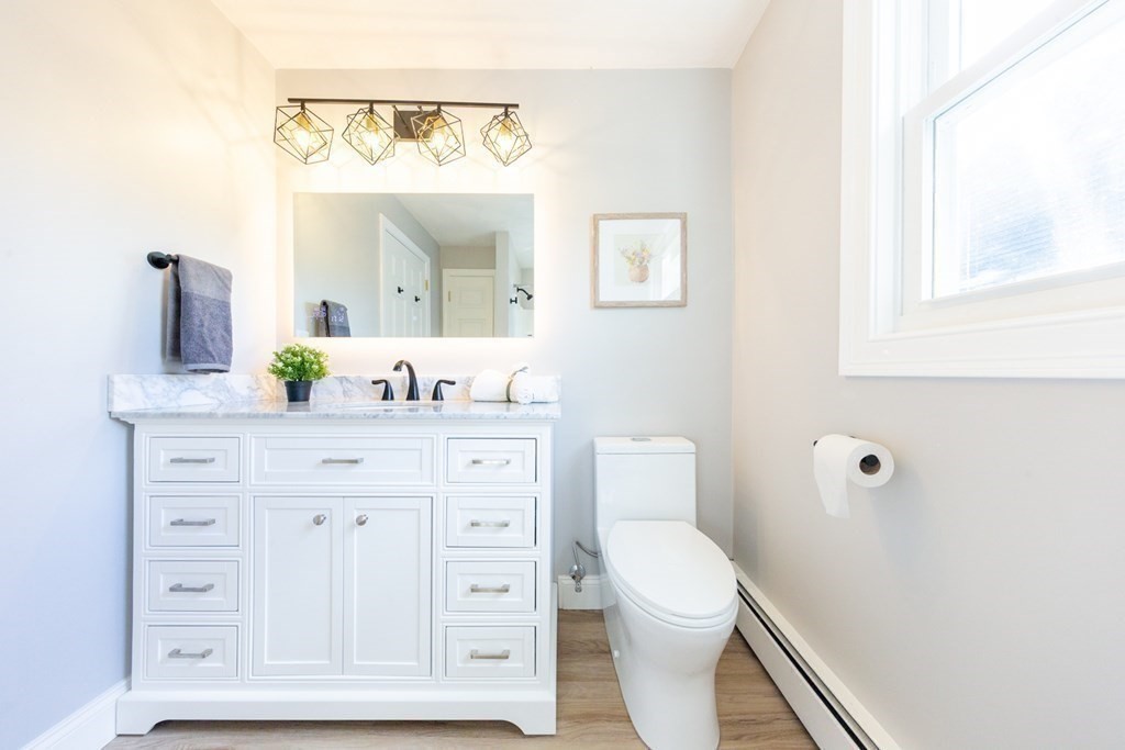 6 King Street Arlington, MA 02474 - Photo 22 of 37 a bathroom with a granite countertop sink mirror and a toilet